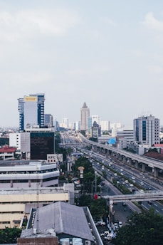 cars on road near city buildings during daytime