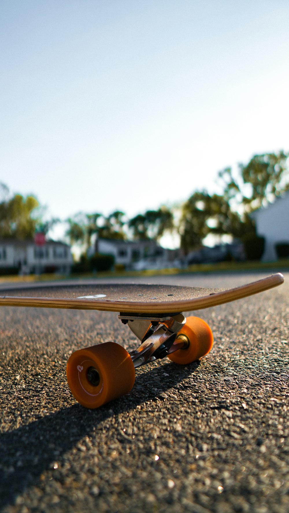 brown and silver skateboard on gray asphalt road during daytime