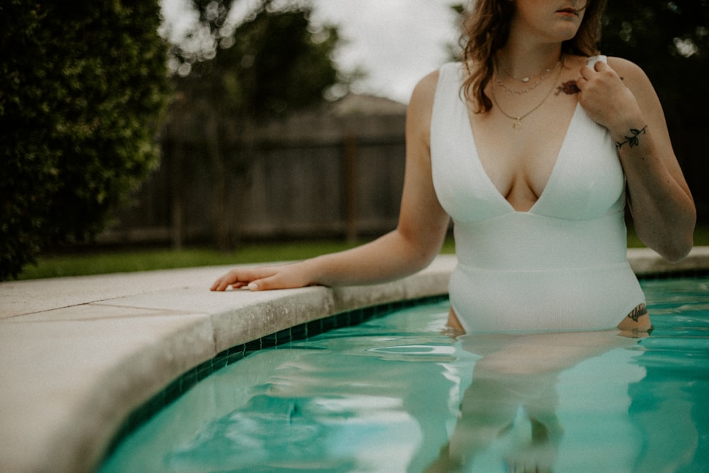 woman in white tank top in swimming pool during daytime