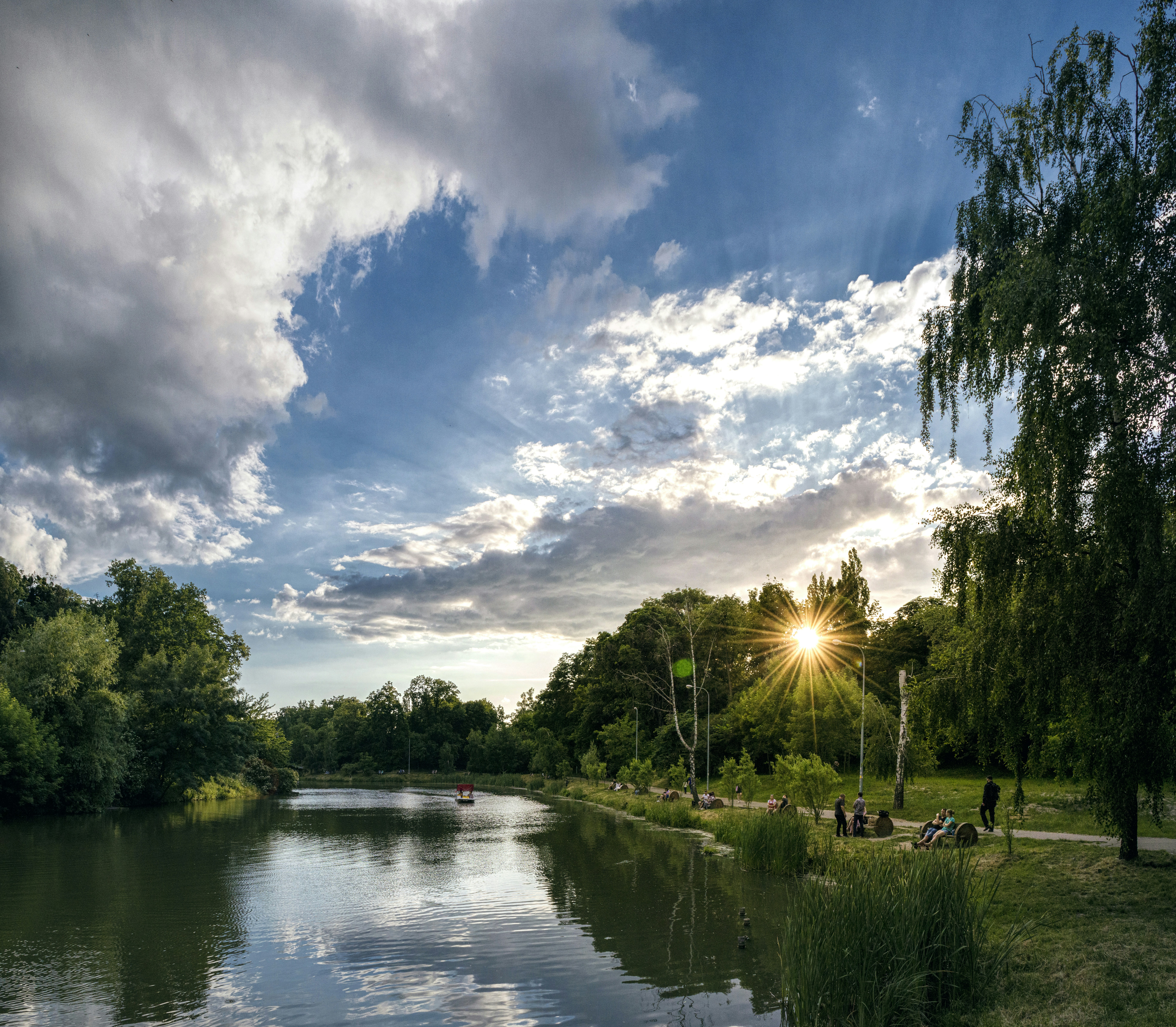 green trees beside river under blue sky and white clouds during daytime