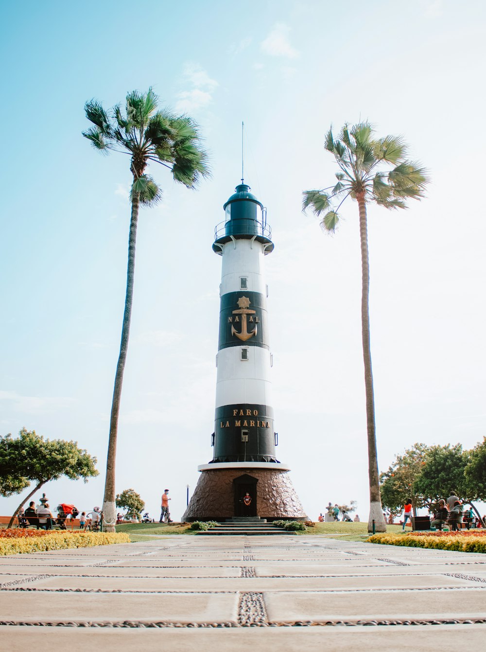 white and black lighthouse near palm trees during daytime