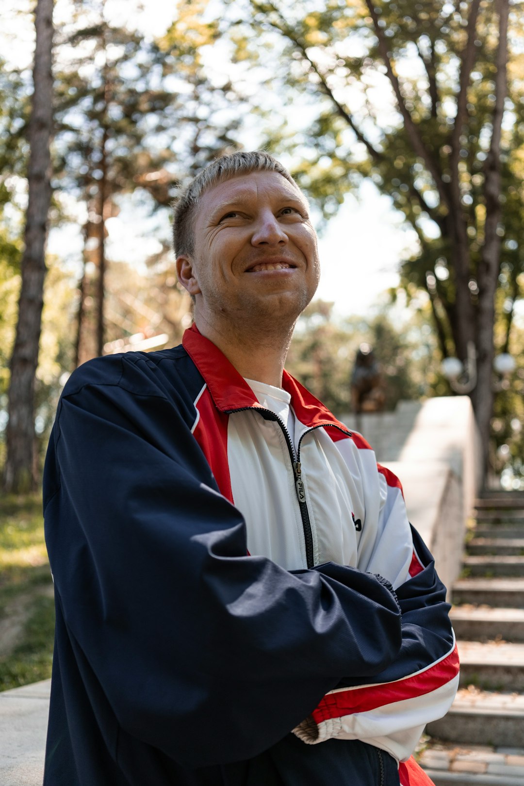 man in black jacket standing near trees during daytime