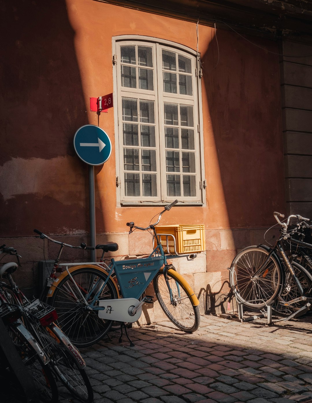 blue city bike parked beside brown concrete building during daytime