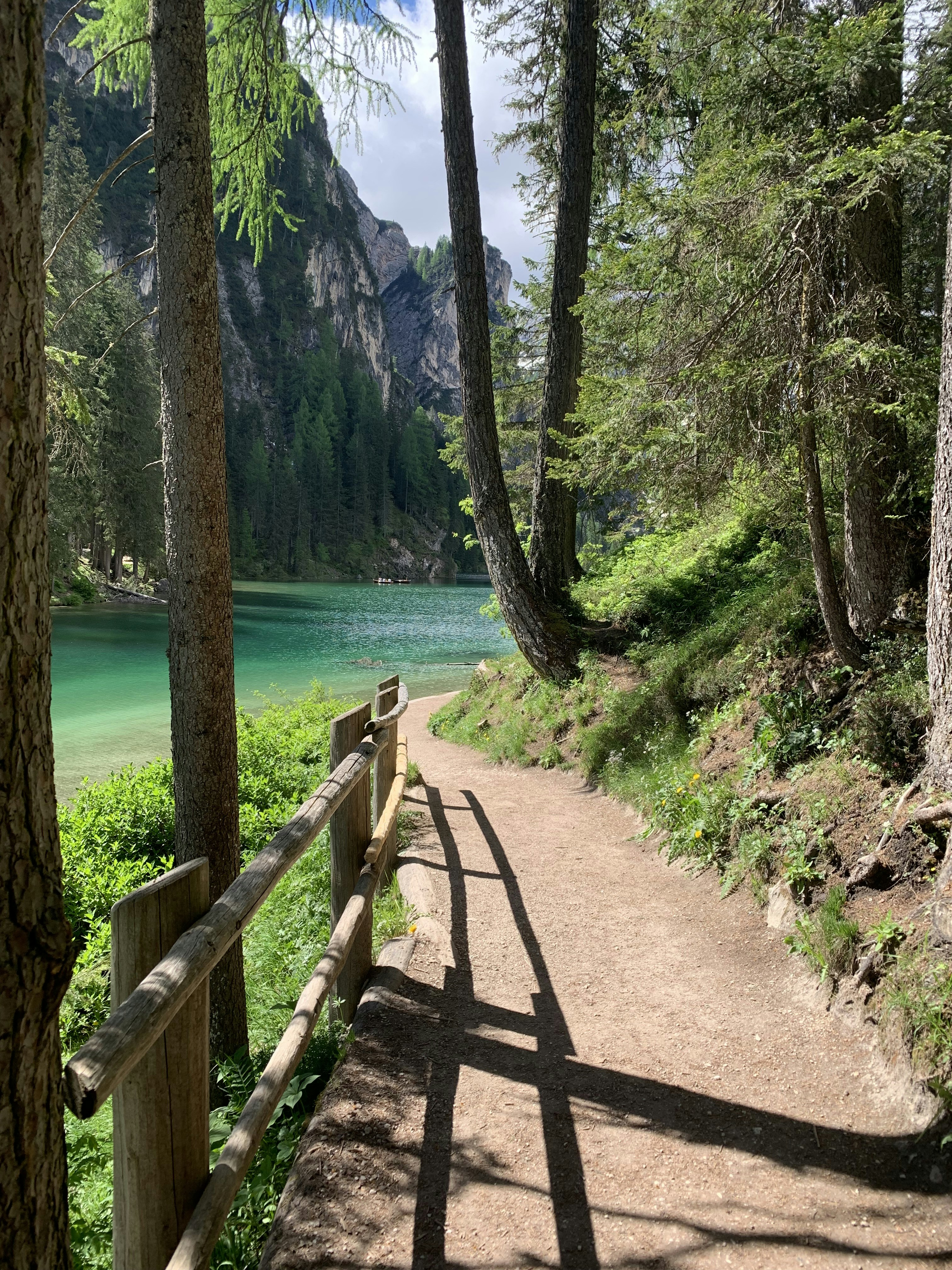 woman in white dress walking on pathway near body of water during daytime