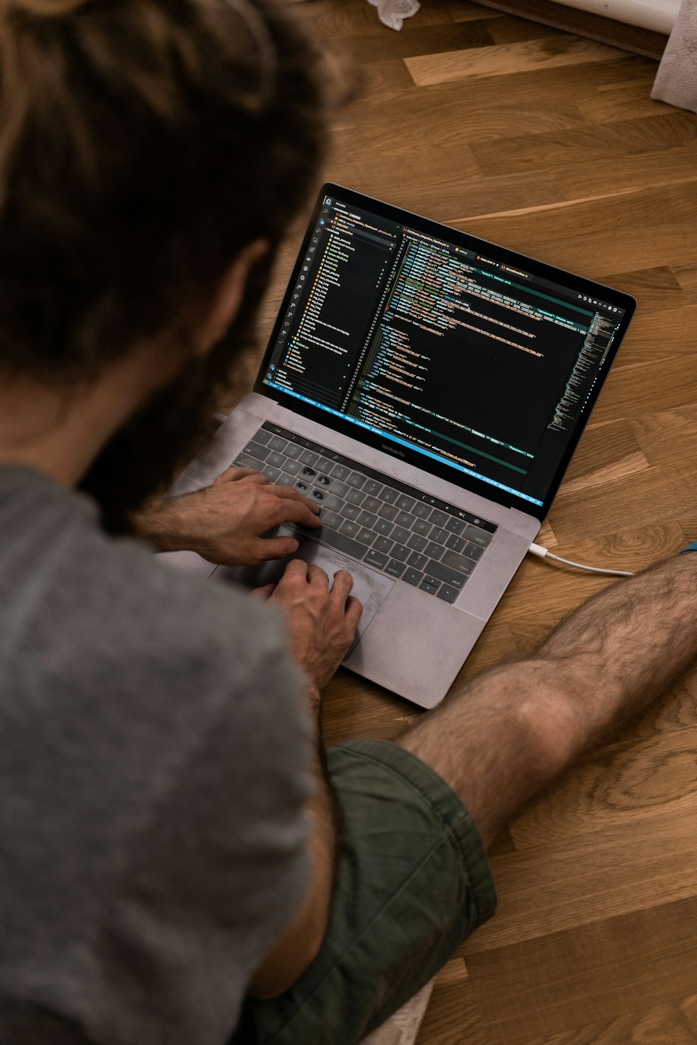 person using macbook pro on brown wooden table