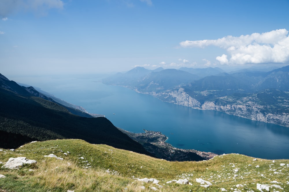 Campo de hierba verde cerca del lago bajo el cielo azul durante el día