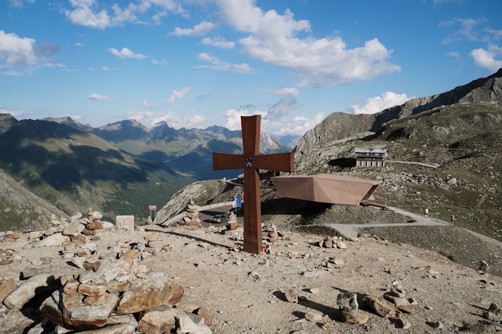 brown wooden cross on rocky ground during daytime