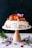 A beautiful pavlova decorated with fresh fruits and flowers.