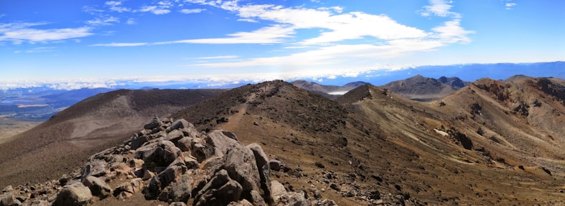A panoramic view of a rugged trail winding through rocky terrain under a clear blue sky