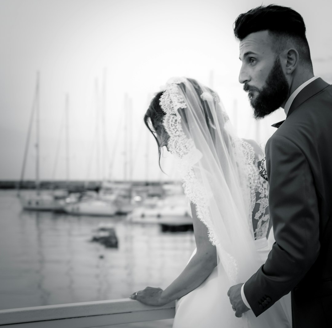 man in black suit jacket and woman in white wedding dress