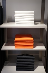 white and orange towels on white wooden shelf
