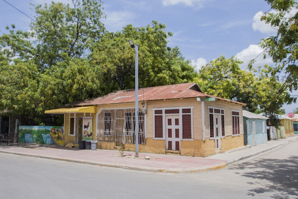 brown and white wooden house near green trees during daytime