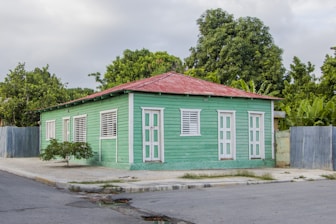 white and brown wooden house near green trees during daytime