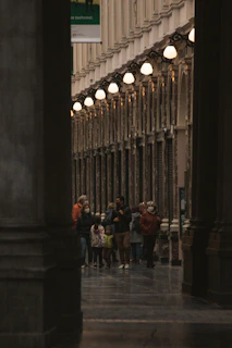 A guided tour group enjoying the historic atmosphere inside the Royal Palace of Madrid.