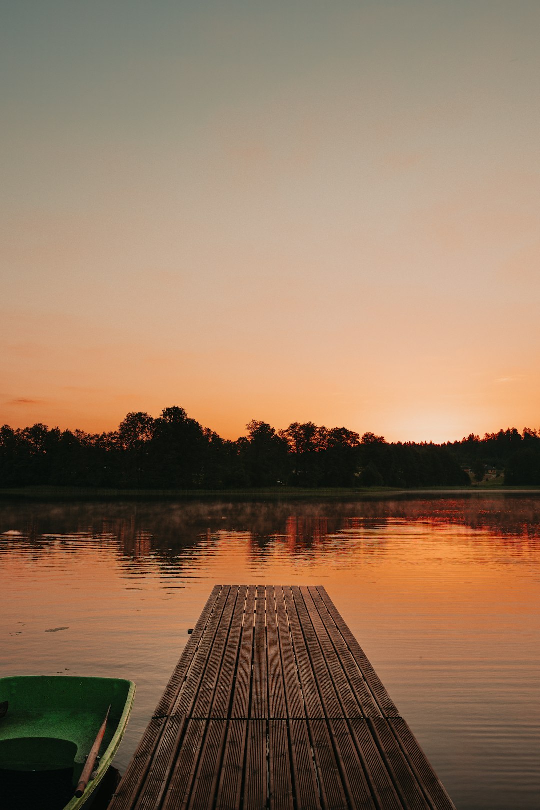 body of water near trees during sunset