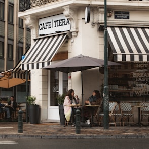 people sitting on bench near store during daytime