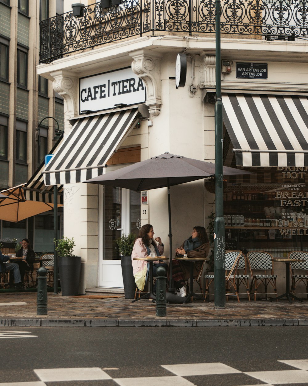 people sitting on bench near store during daytime