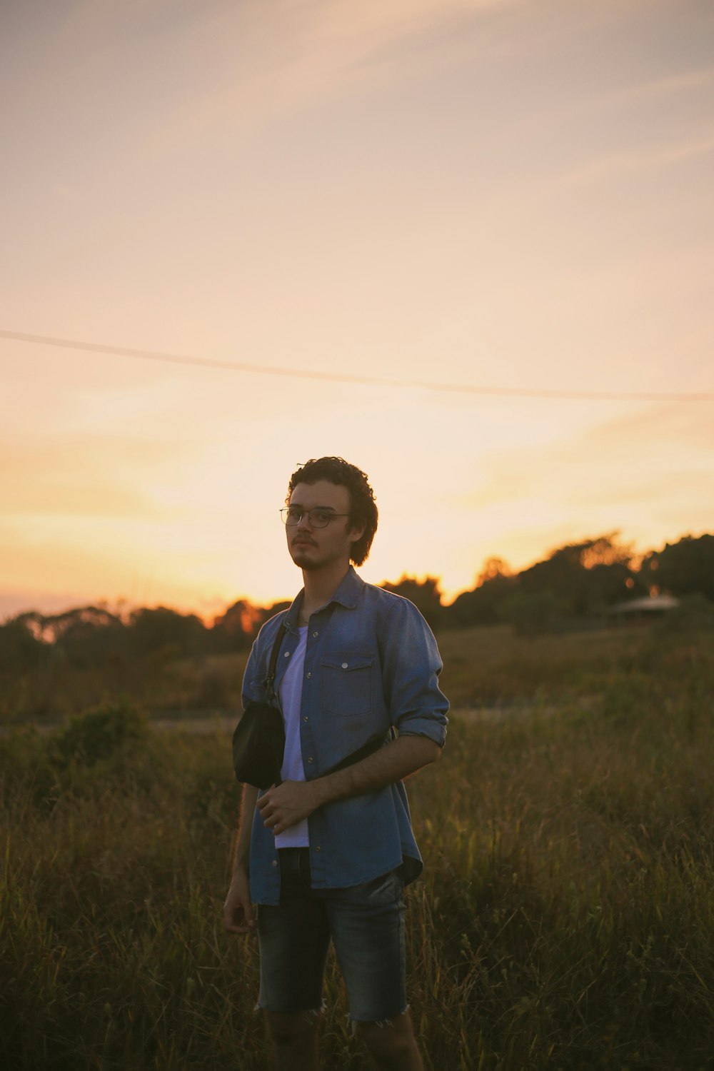 man in blue dress shirt standing on green grass field during daytime