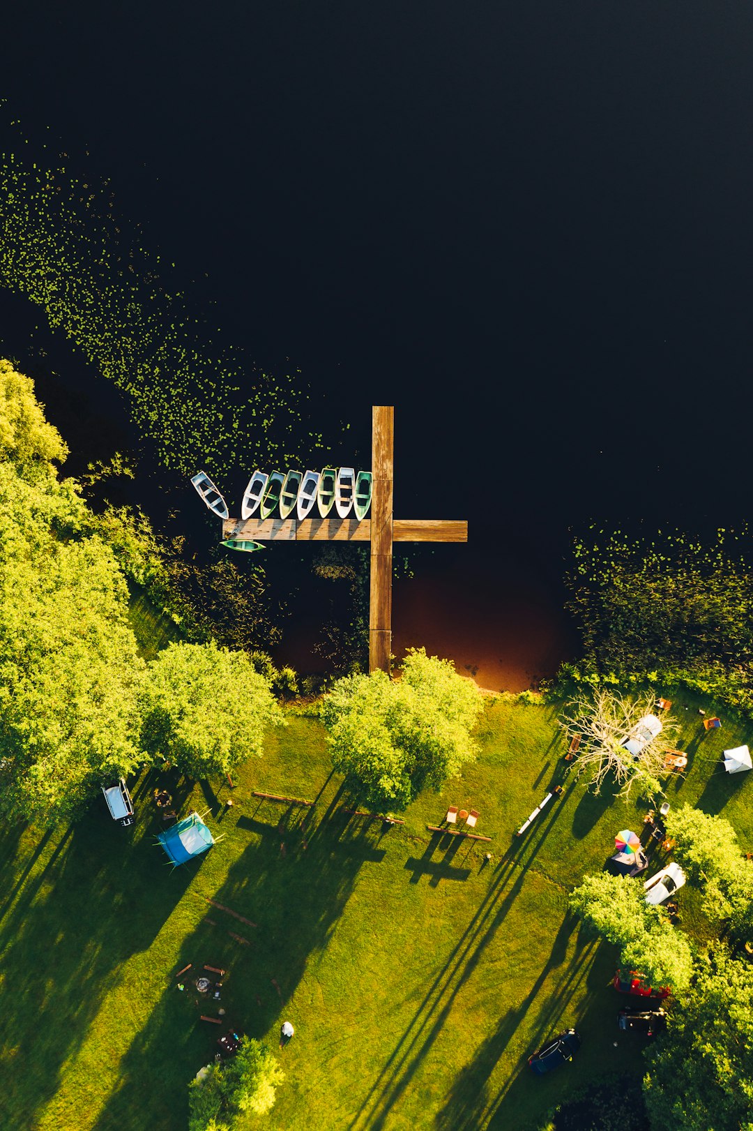 brown wooden cross with cross on top surrounded by green trees during nighttime
