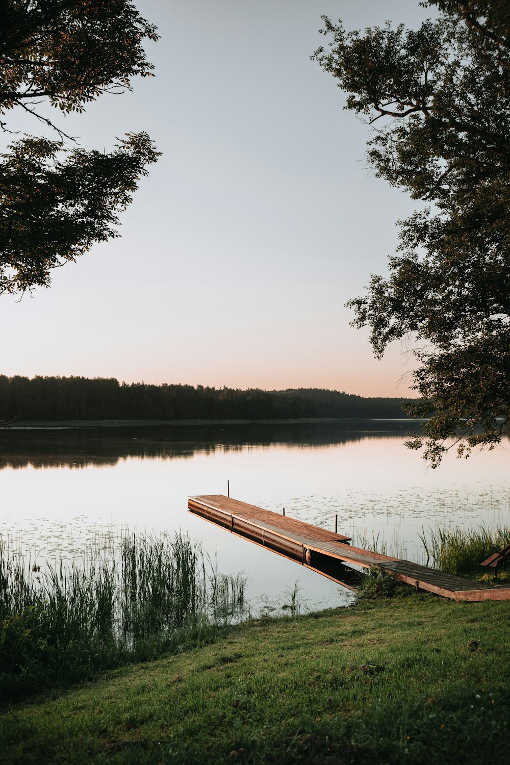 Quai en bois brun sur le lac pendant la journée