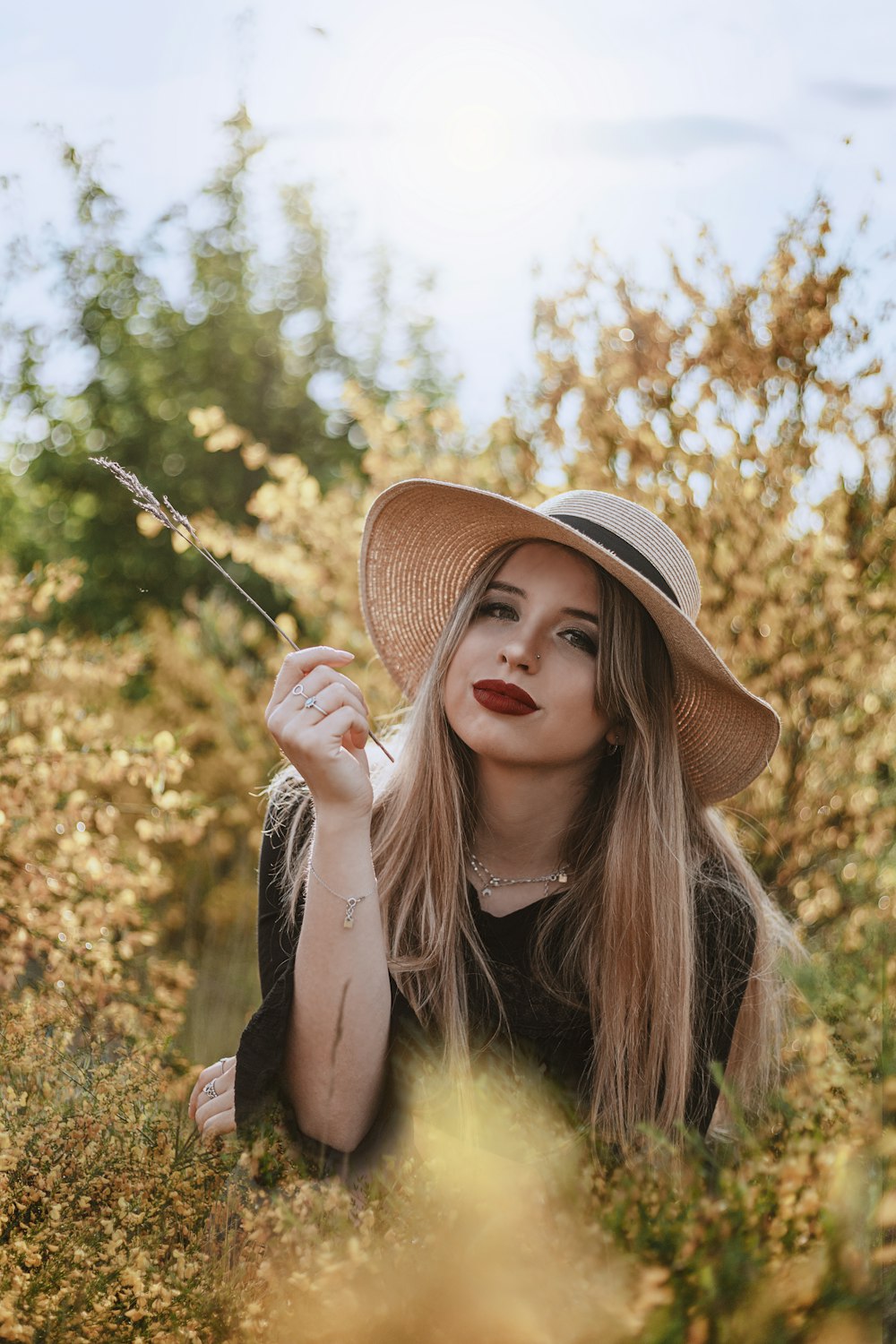 Femme en chapeau marron tenant un bâton