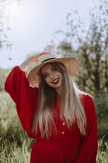 woman in red long sleeve shirt wearing brown fedora hat