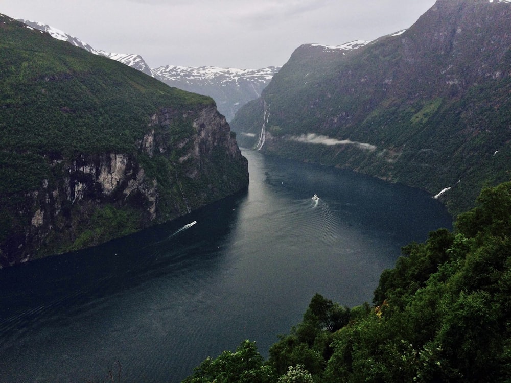 green and brown mountain beside river during daytime