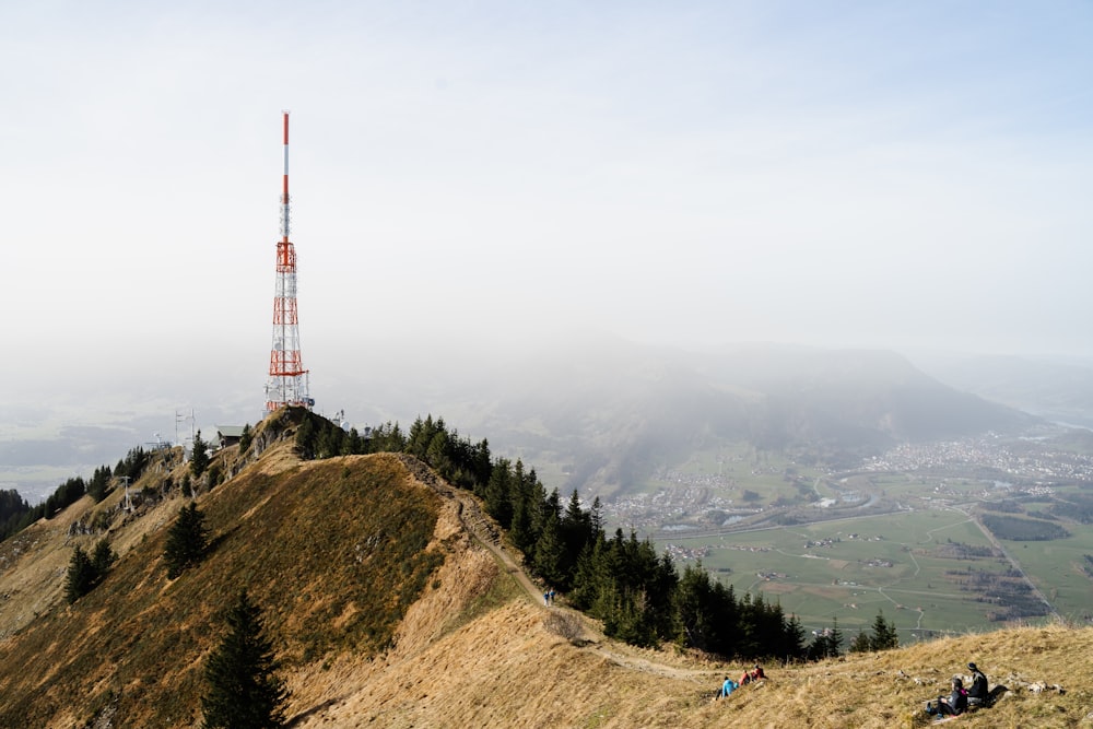 red and white tower on top of mountain