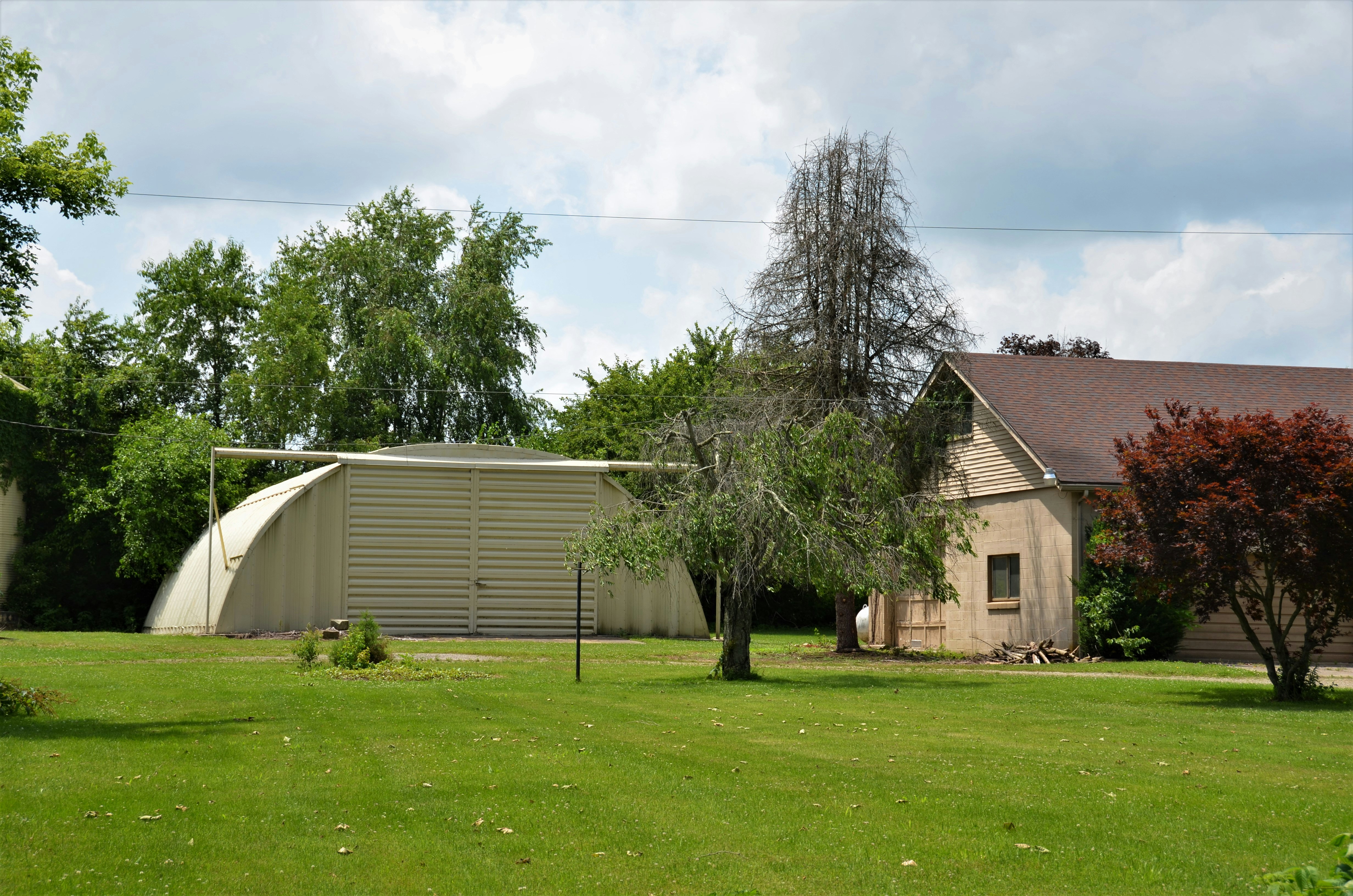 White and brown house near green tree under white sky during daytime ...