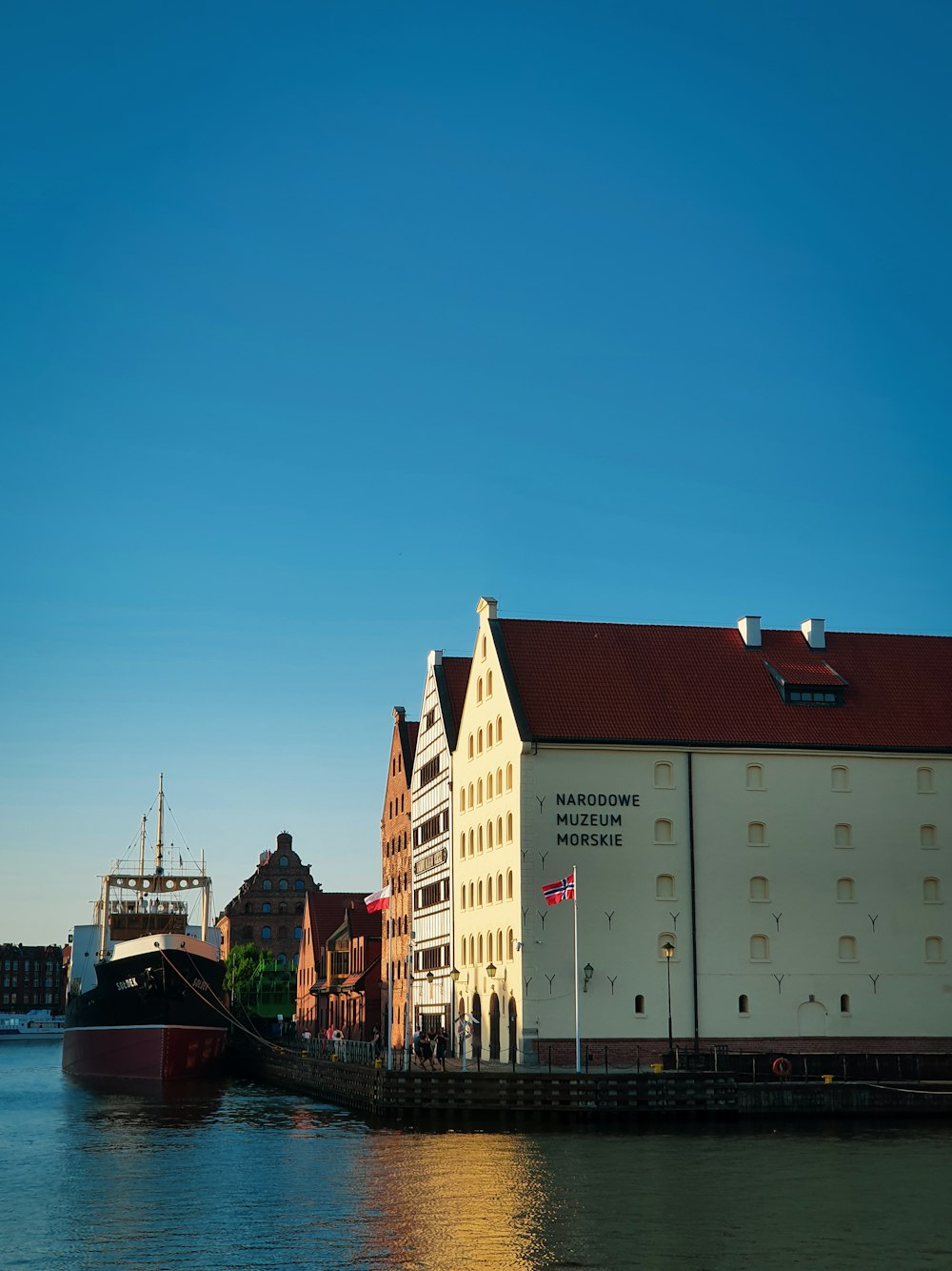 white and brown concrete building beside body of water during daytime