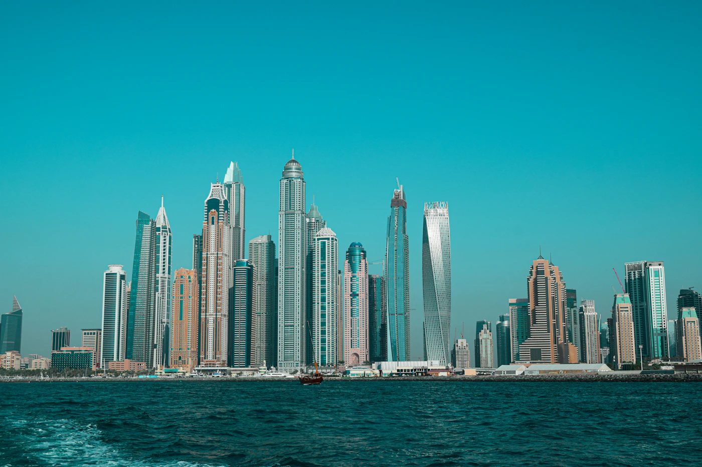 The Dubai skyline seen across open water during the day