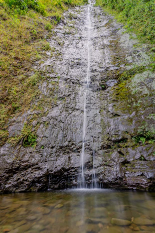 waterfalls on brown rocky mountain during daytime