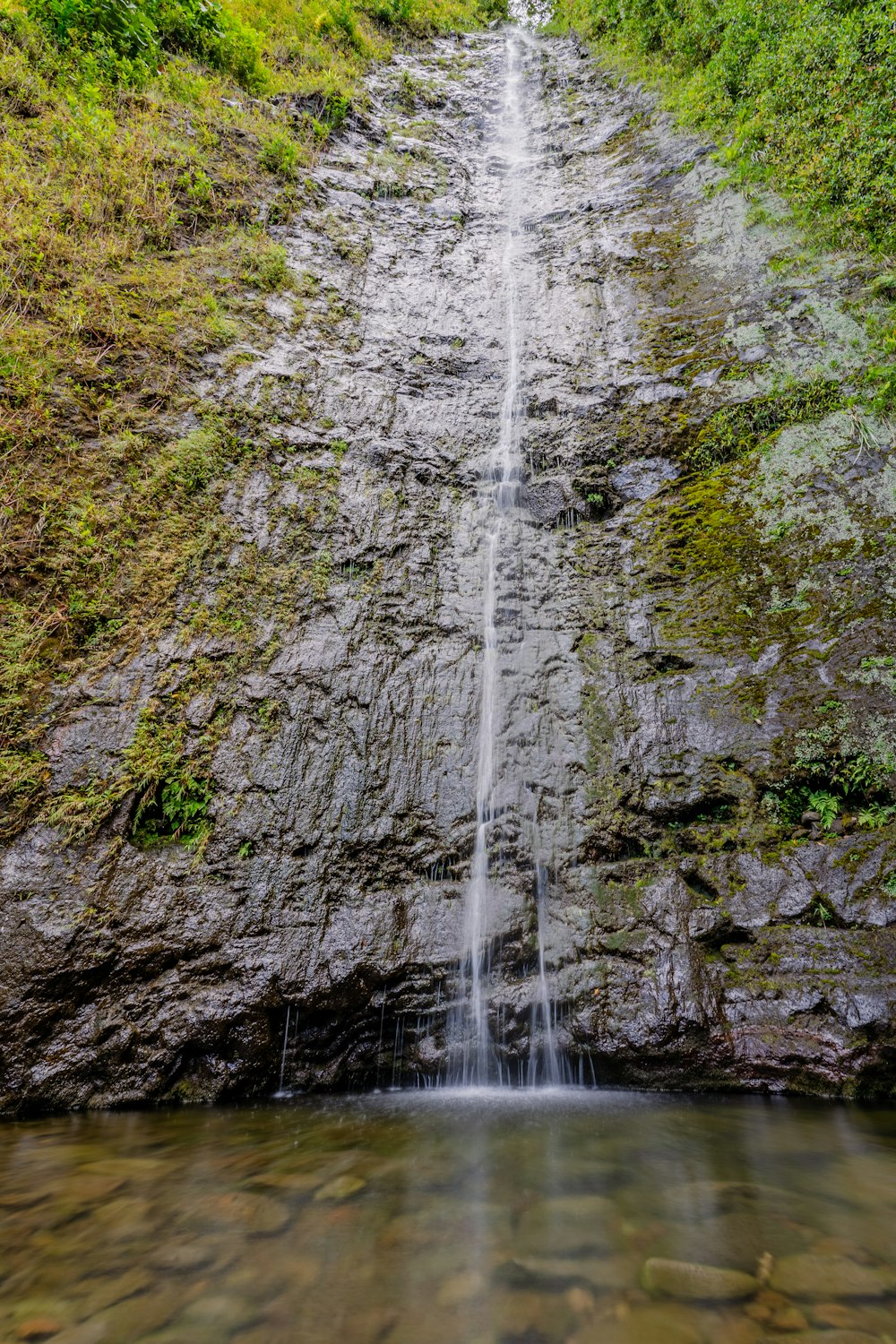 waterfalls on brown rocky mountain during daytime