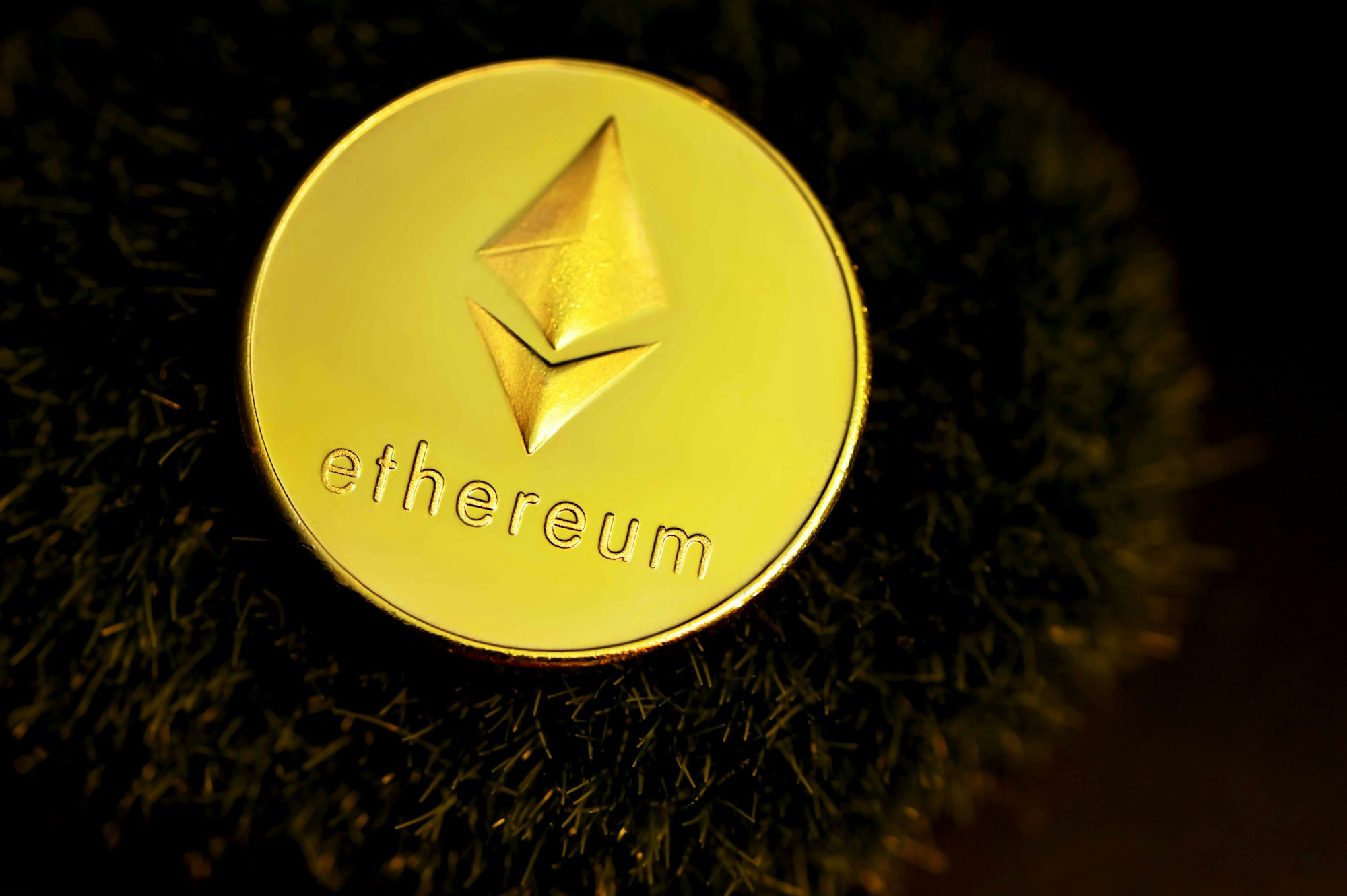 An Ethereum coin on a grass patch