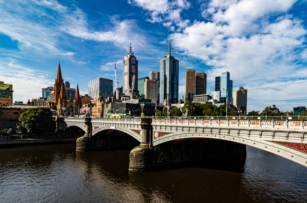 white bridge over river near city buildings during daytime