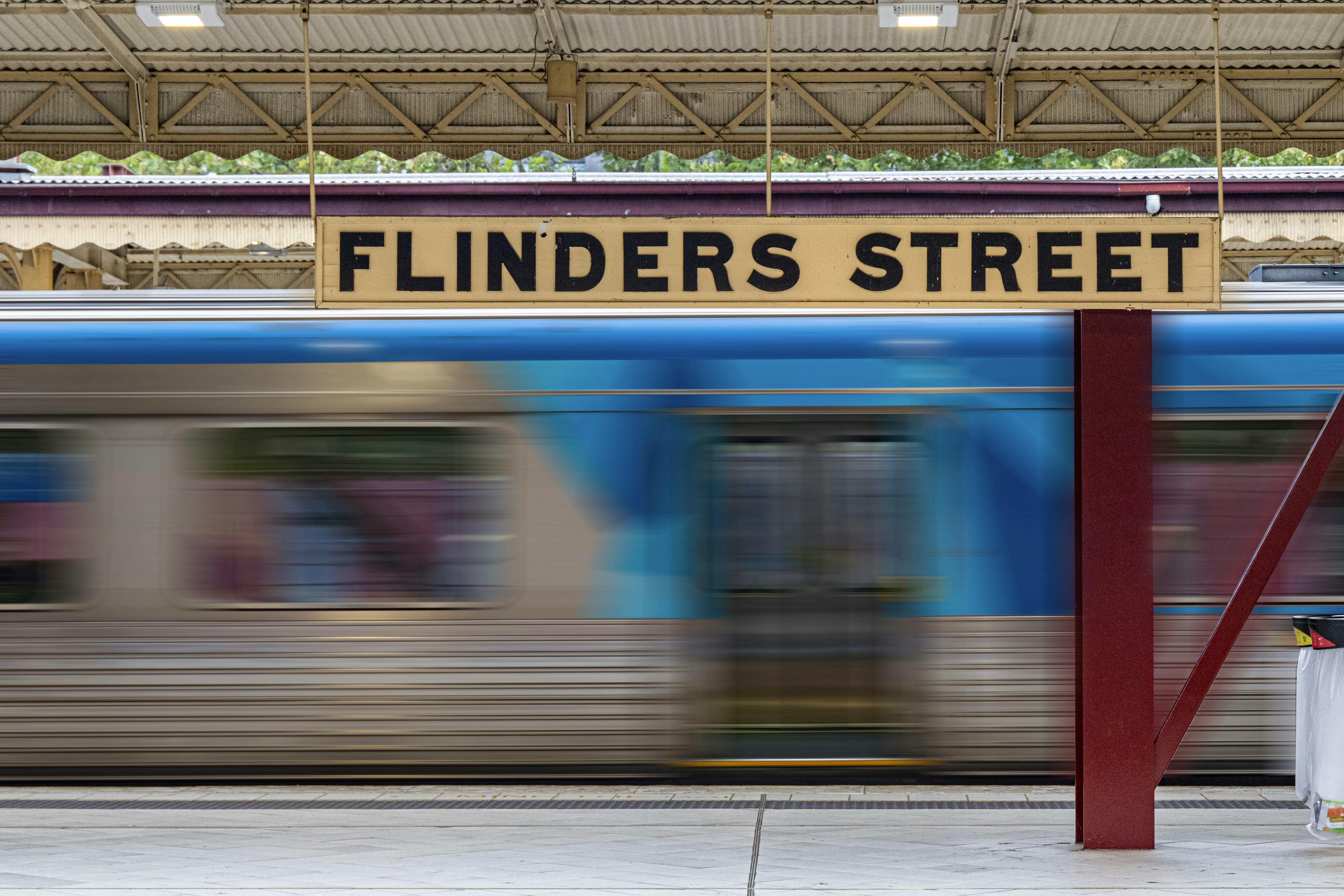 blue and yellow train in a train station, Flinders Street railway station is located on the corner of Flinders and Swanston streets in the central business district of Melbourne, Victoria, Australia.