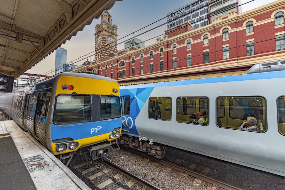 yellow and blue train on rail tracks during daytime