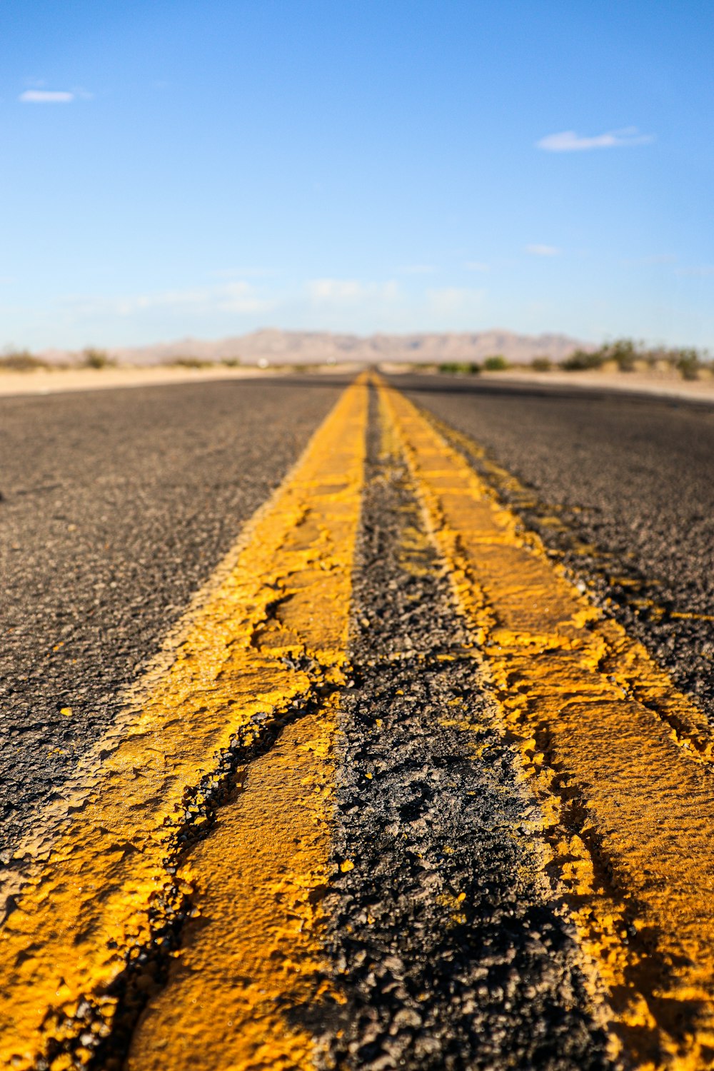 yellow and black road in the middle of the field