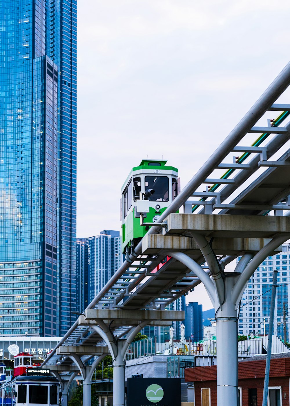 Grüner Zug tagsüber auf der grauen Brücke