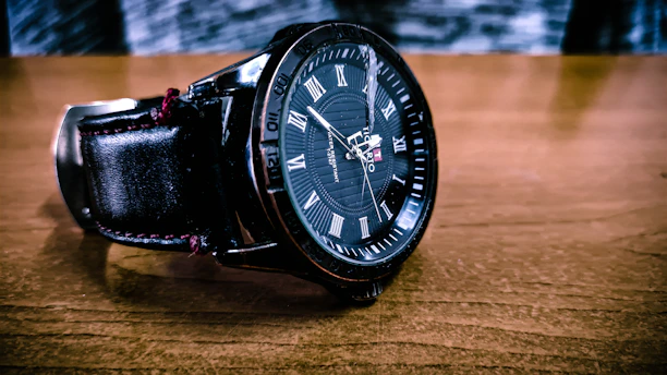 Close-up of a stylish watch from romen displayed on a wooden table.