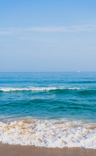 ocean waves crashing on shore during daytime