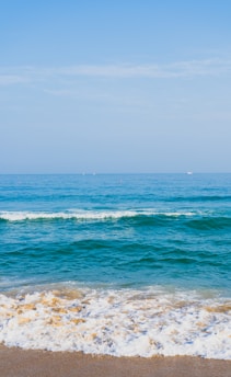 ocean waves crashing on shore during daytime