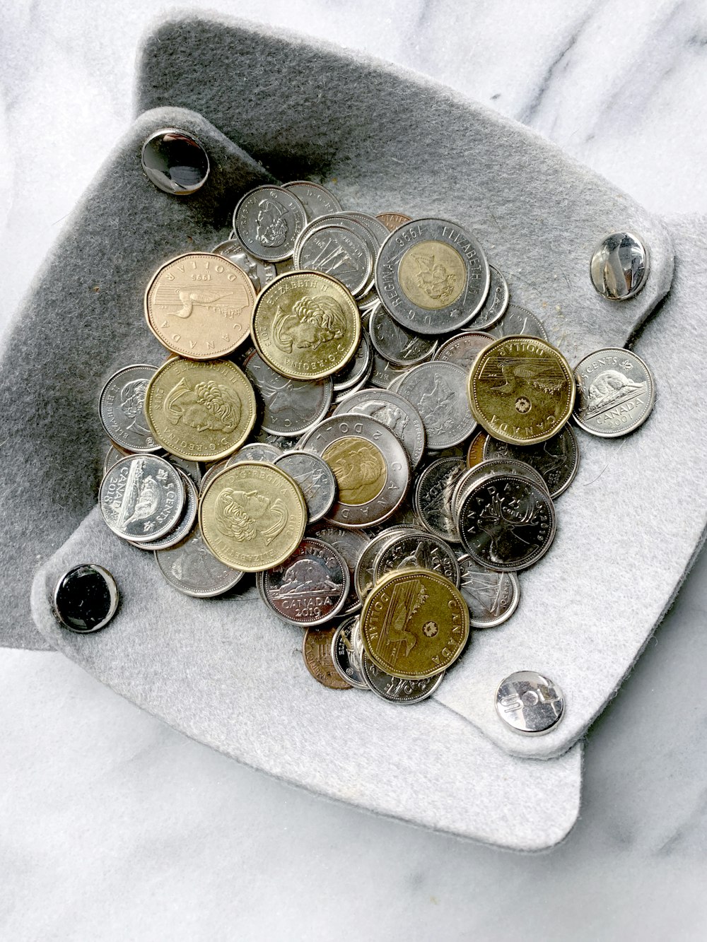 Monedas redondas de oro y plata sobre superficie gris