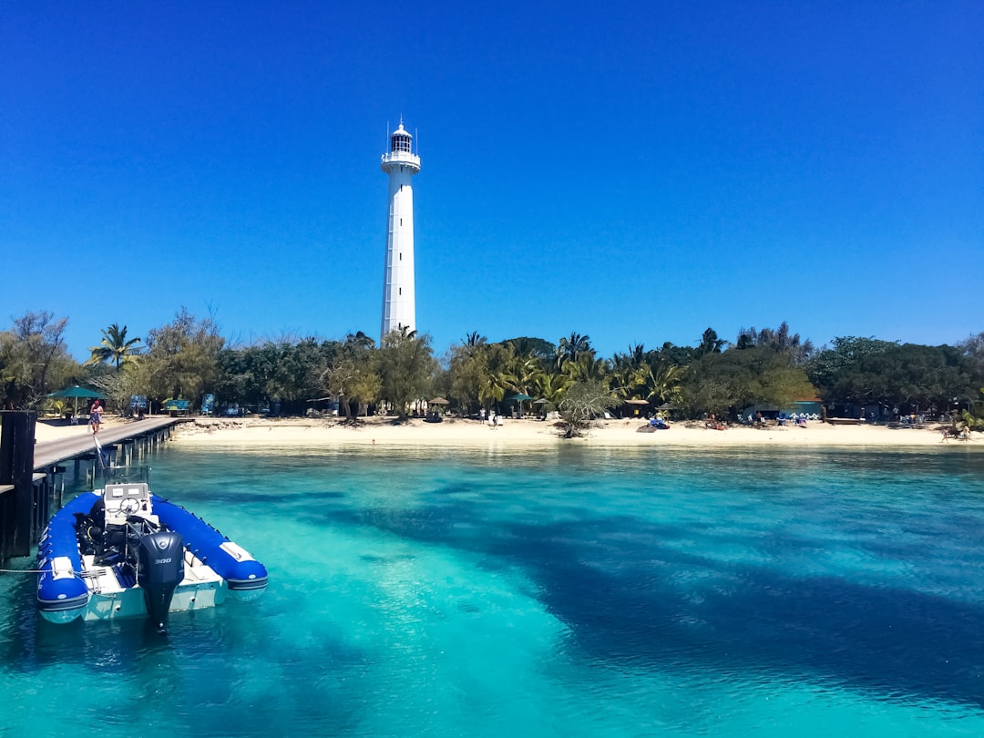 white lighthouse near body of water during daytime