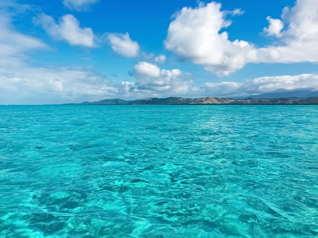 blue sea under blue sky and white clouds during daytime