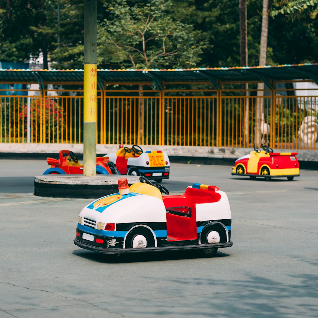 people riding red and white go kart on road during daytime