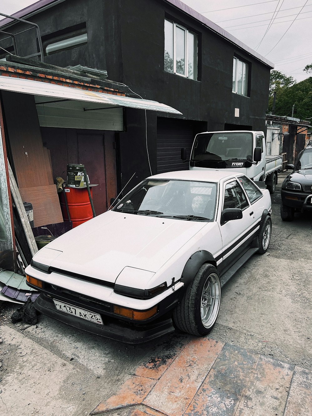 chevrolet camaro cinza estacionado ao lado da casa vermelha e branca