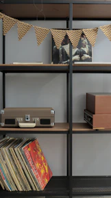 Industrial metal media stand holding a vintage record player and a stack of vinyl records.