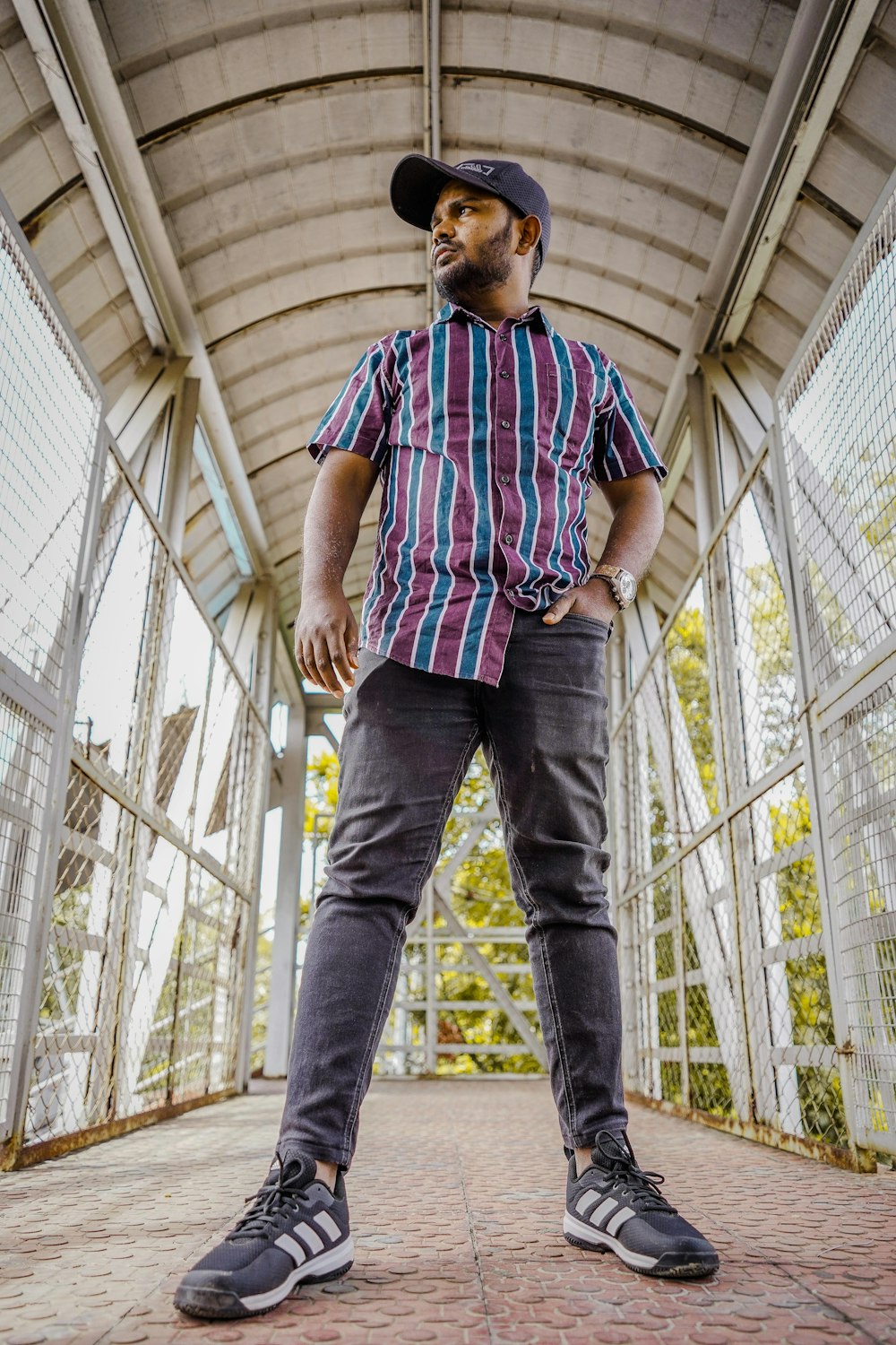 man in blue red and white plaid button up t-shirt and blue denim jeans standing