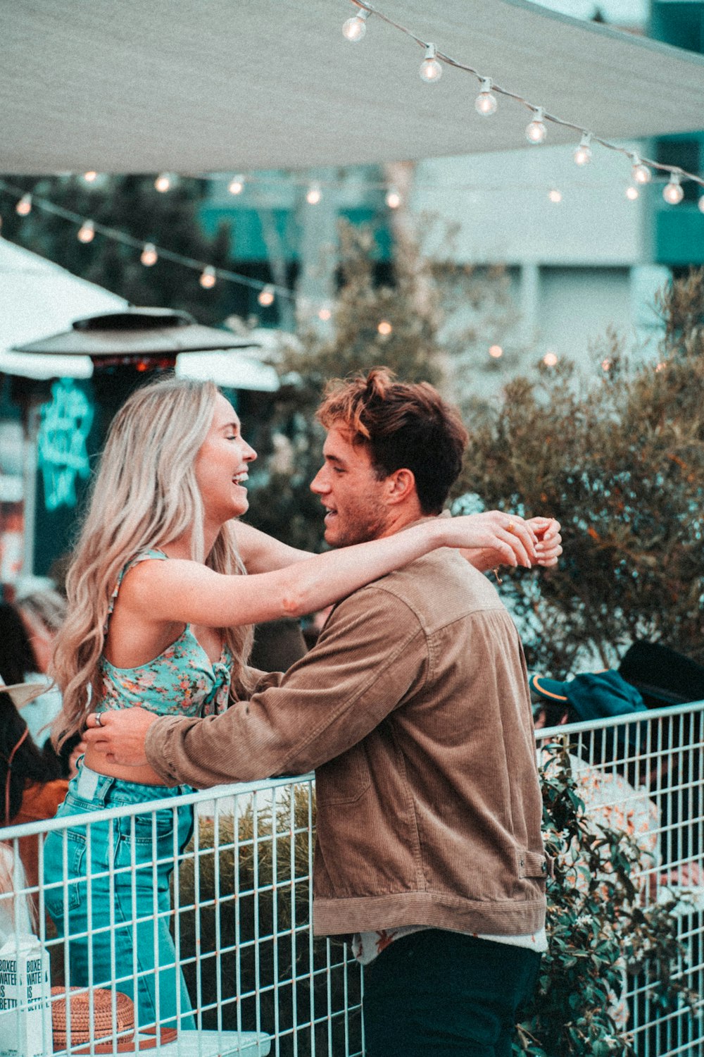 man and woman kissing on the street during daytime